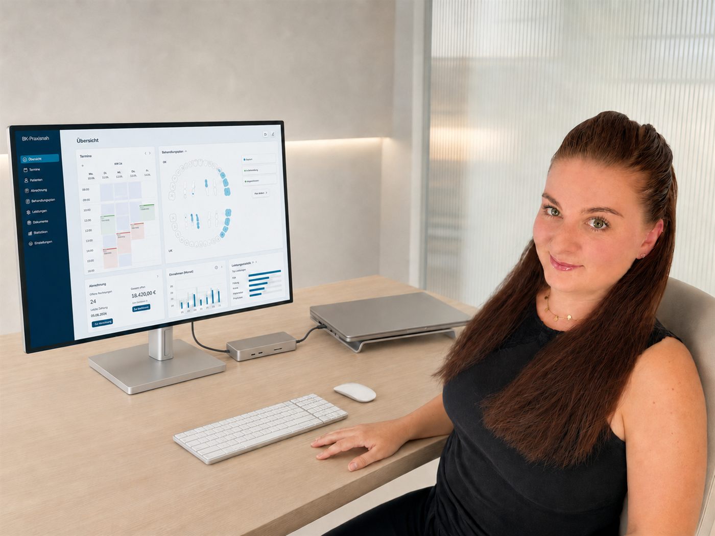 Bettina Kosmidis an ihrem Arbeitsplatz, vor sich ein Monitor mit der geöffneten Abrechnungsübersicht einer Zahnarztpraxis